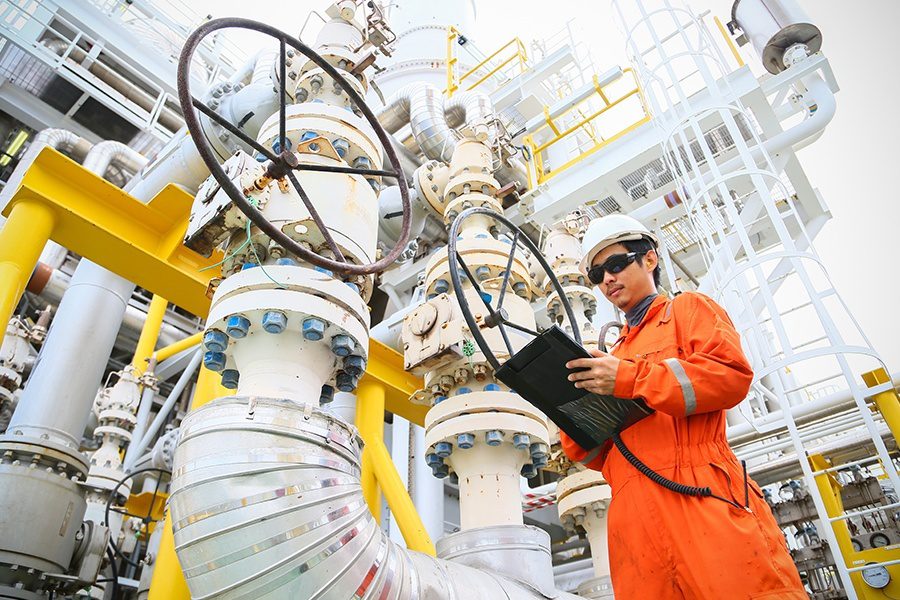 Oil and Gas Insurance - Operator Recording Oil and Gas Process at an Offshore Oil and Gas Rig in the Ocean